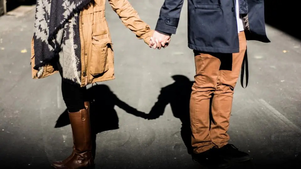 Sexdate Frauenfeld: Paar hält Händchen, die Schatten auf dem Boden