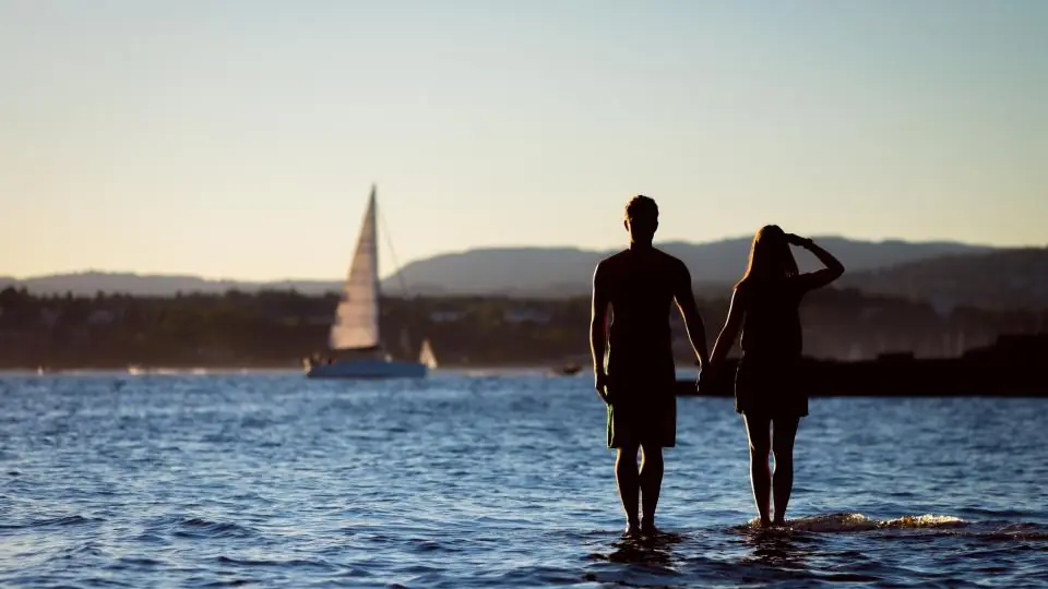 Sexdate Glarus: Paar steht in der Abendsonne im Wasser
